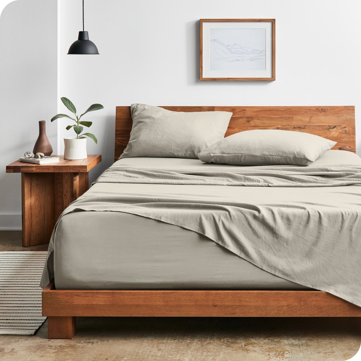 Modern bedroom with washed sheets draped over the end and the side of the bed