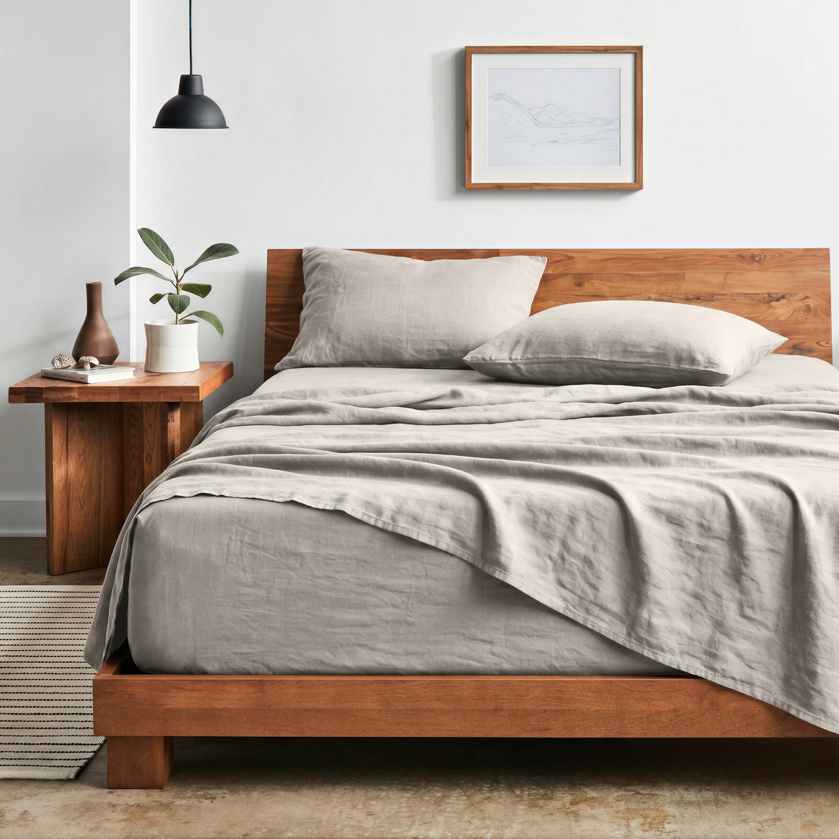 Bedroom with sheet set on a wooden bed frame and side table