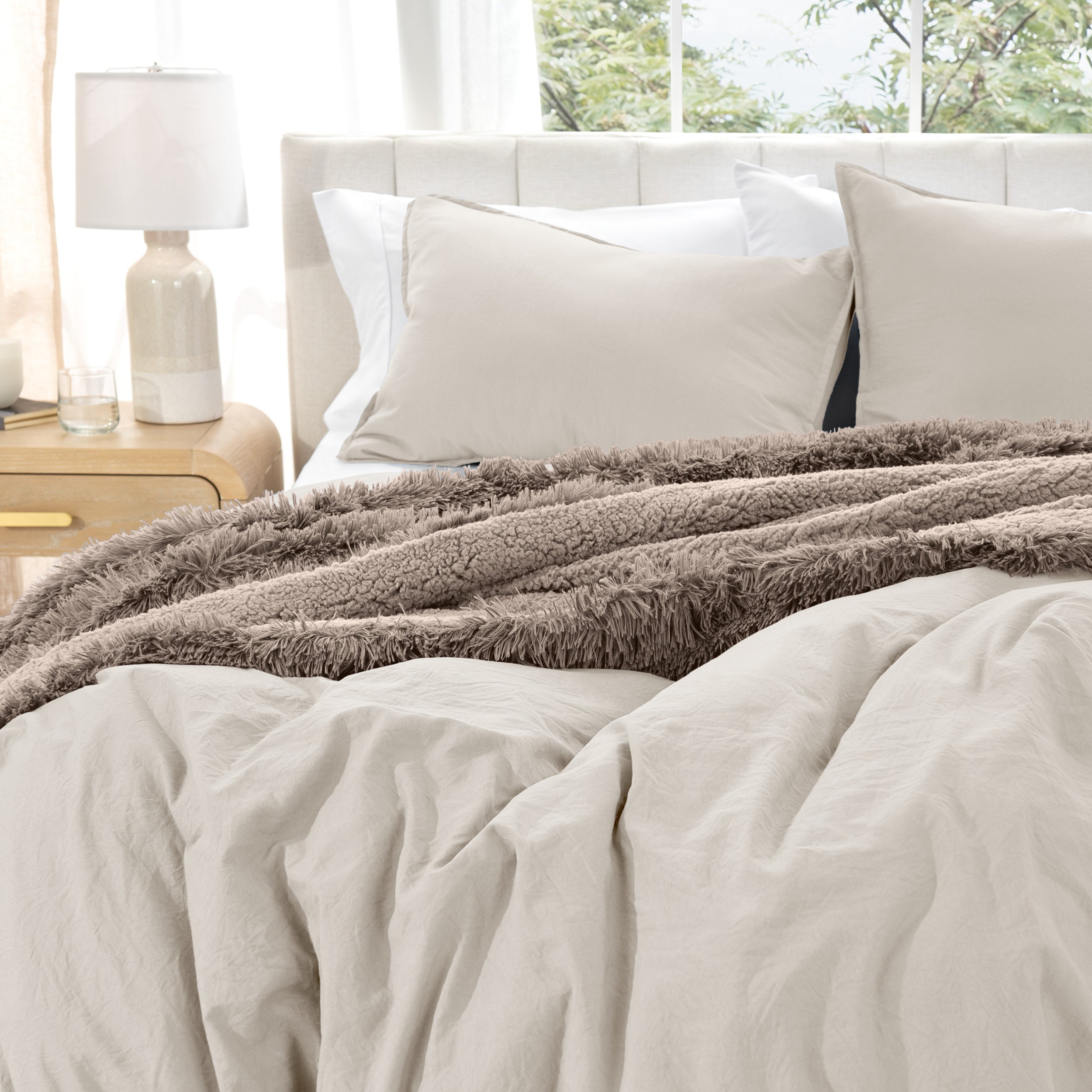 Washed duvet cover set on a bed with pillows and a lamp in the background