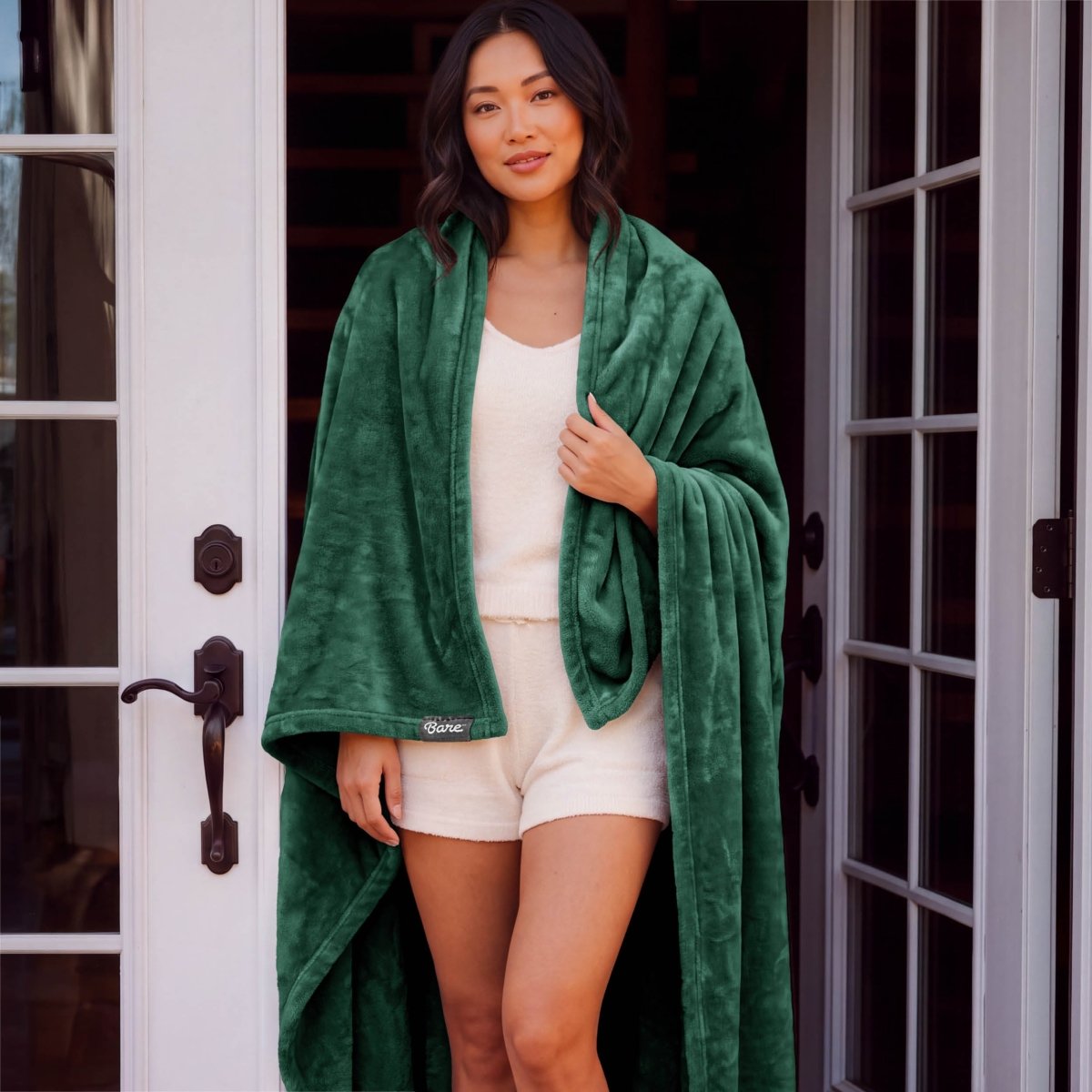 A woman standing with a microplush blanket wrapped around her