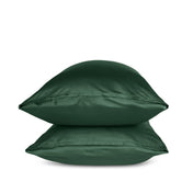 Two green pillows stacked on a white background
