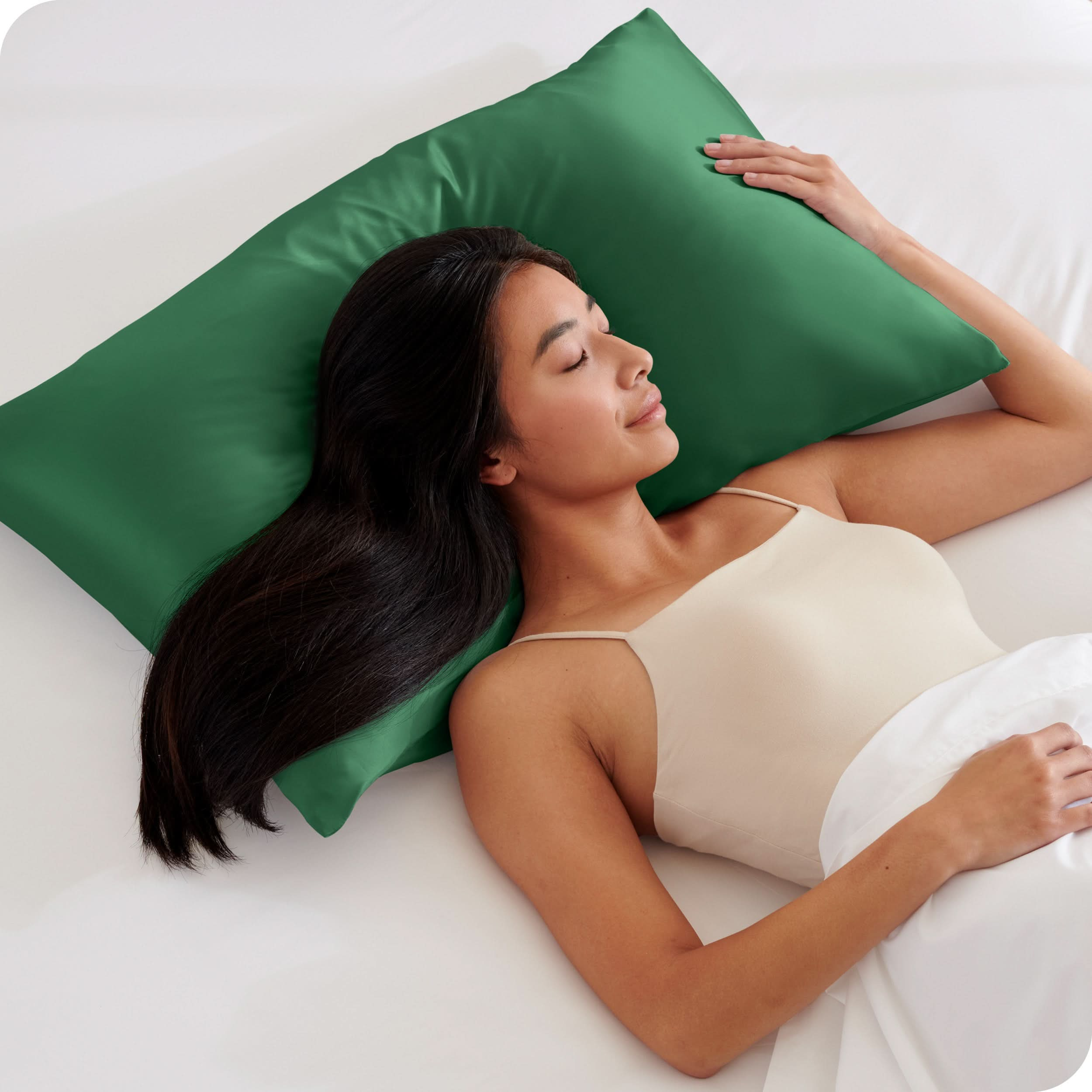 A woman is sleeping with her head on a silk pillowcase