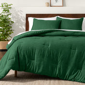 Bedding set on a bed in a bedroom with a side table and lamp.