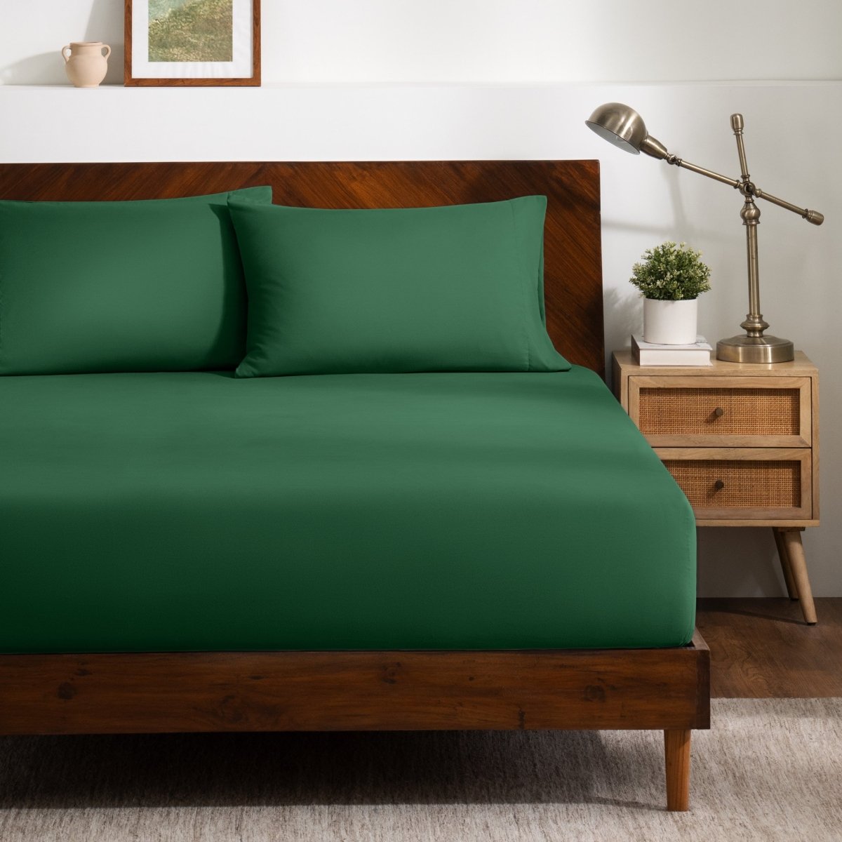 A bed dressed in a fitted sheet and two matching pillowcases.