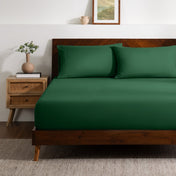 A bed made with a single fitted sheet and two matching pillowcases.
