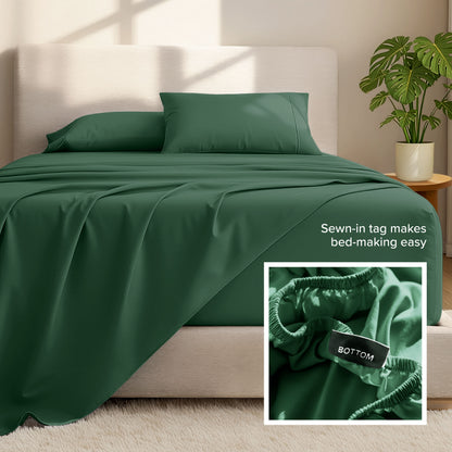 Bed sheets and pillows on a bed with a plant in the background