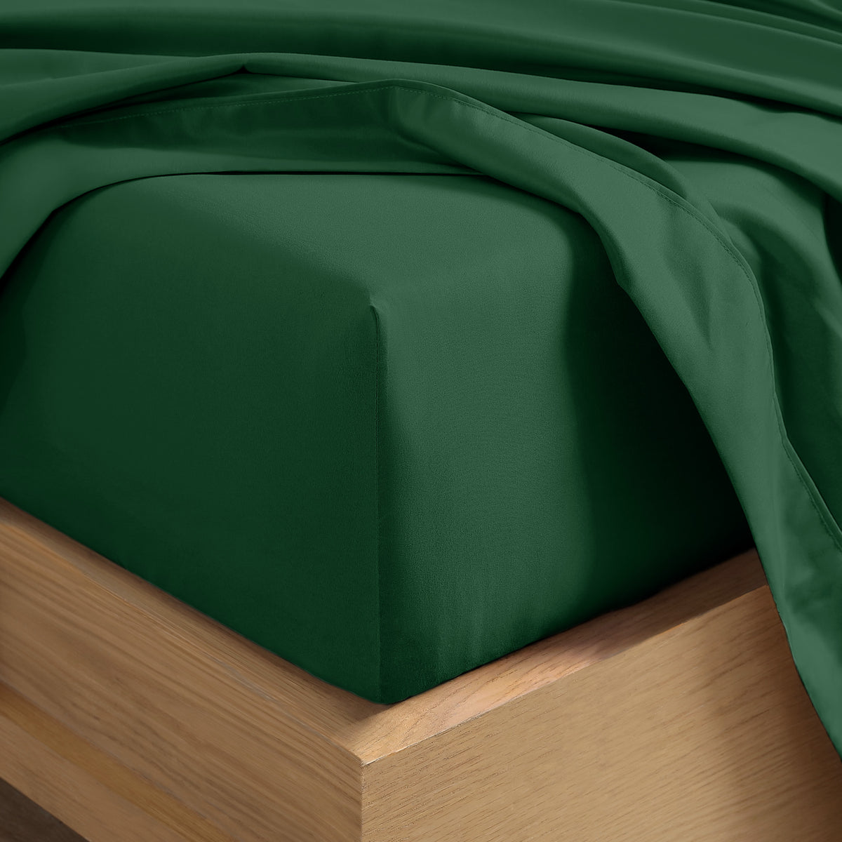 Close up of the corner of a mattress with a fitted sheet and flat sheet on it