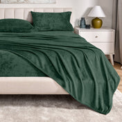 Microplush sheet set on a bed in a bedroom setting with a nightstand and lamp.