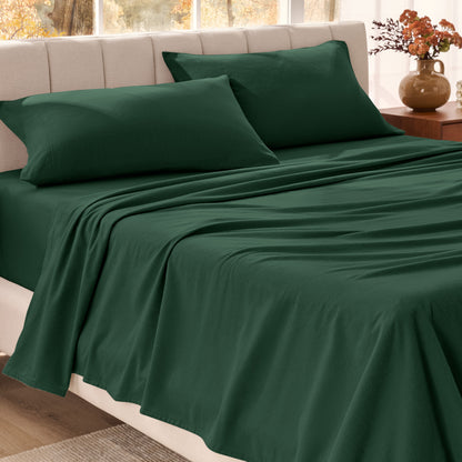 Bed sheets on a neatly made bed in a bright bedroom with large windows.