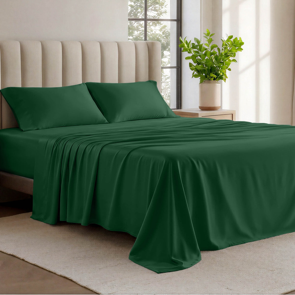 Organic cotton jersey sheets on a bed with a wicker headboard in a room with plants and a lamp.