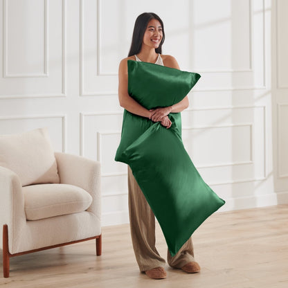 Woman holding 2 pillows with satin pillowcases on them