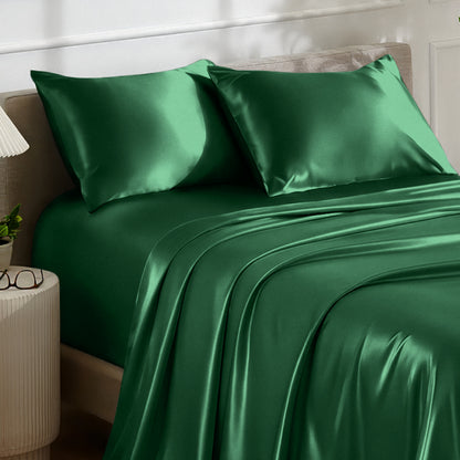 Satin bedding set on a bed with a nightstand and lamp in the background.