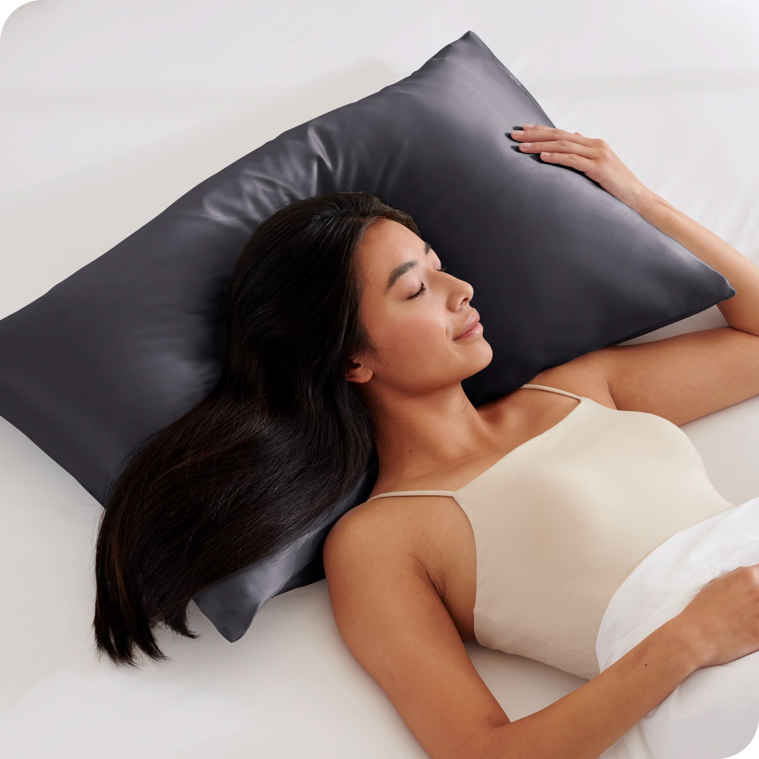 A woman is sleeping with her head on a silk pillowcase