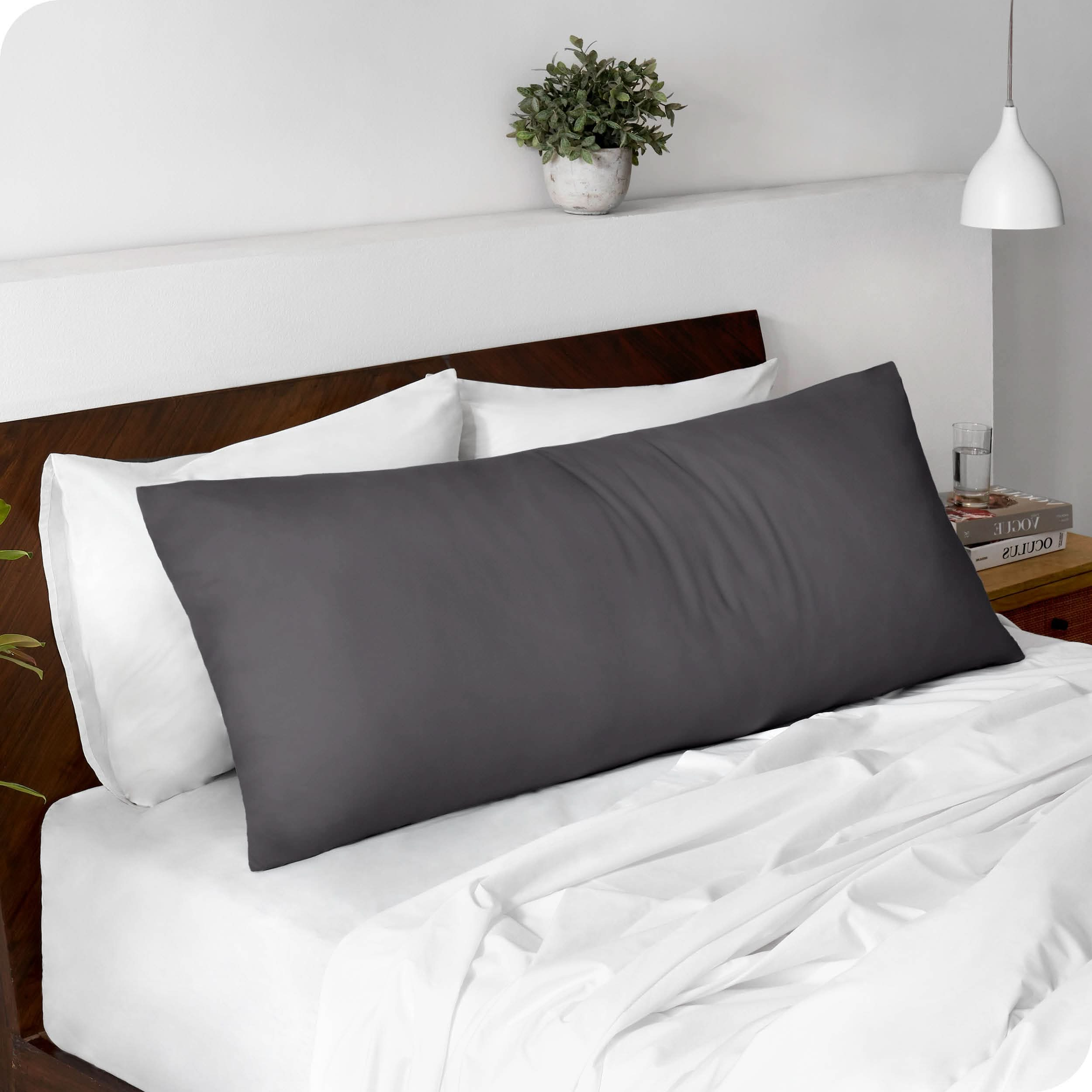 A body pillowcase on a pillow set against a headboard