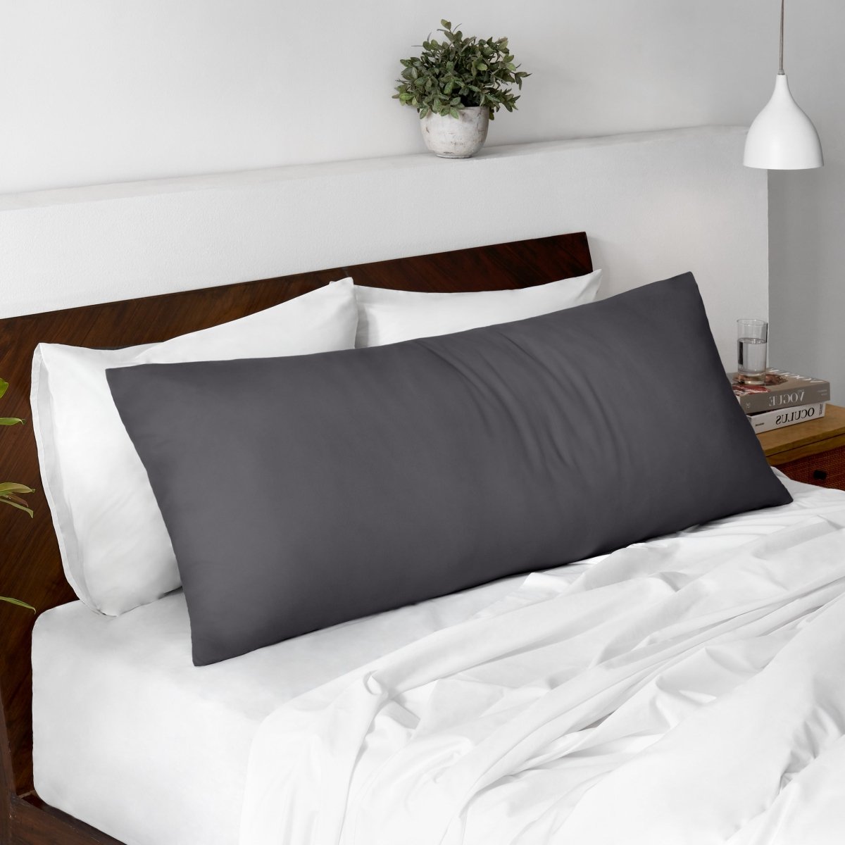 Body pillow on a bed with a wooden headboard and minimal decor.