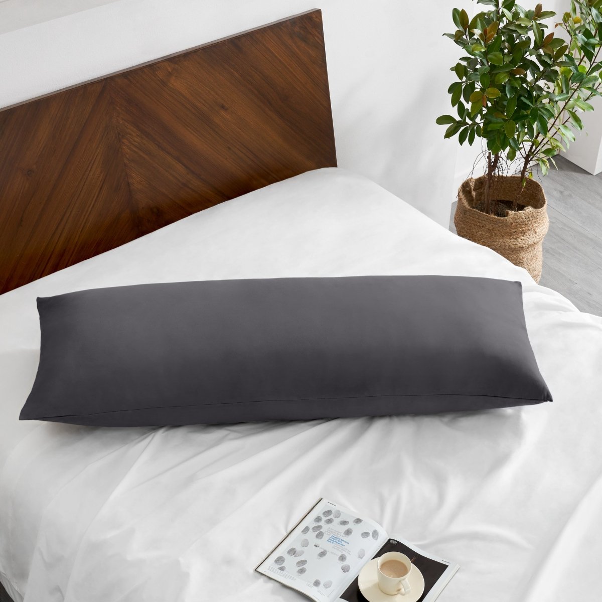 Pillowcase on a body pillow with a wooden headboard and plant in the background