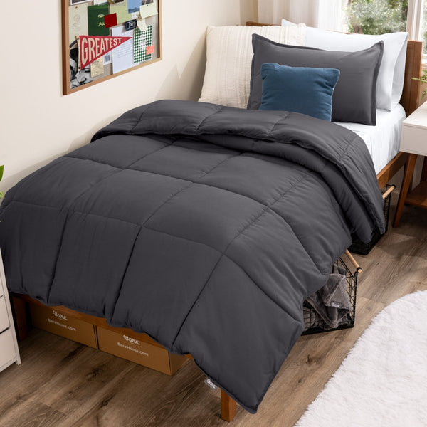 Bed with comforter and pillows in a dorm room