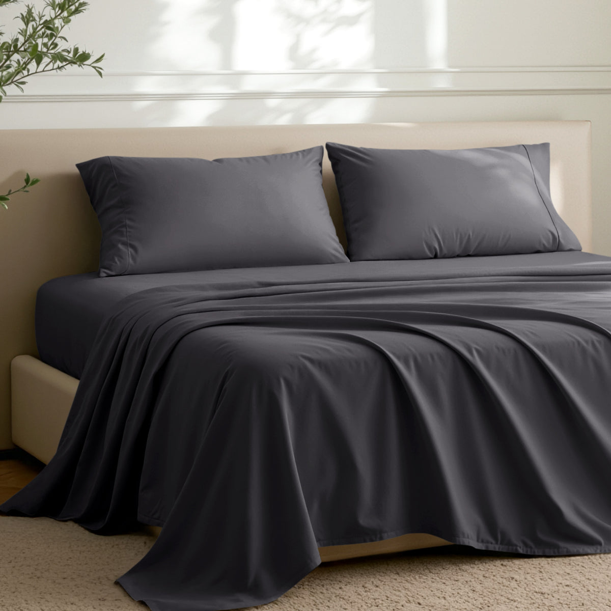 Microfiber sheets on a bed in a well-lit room with a plant.