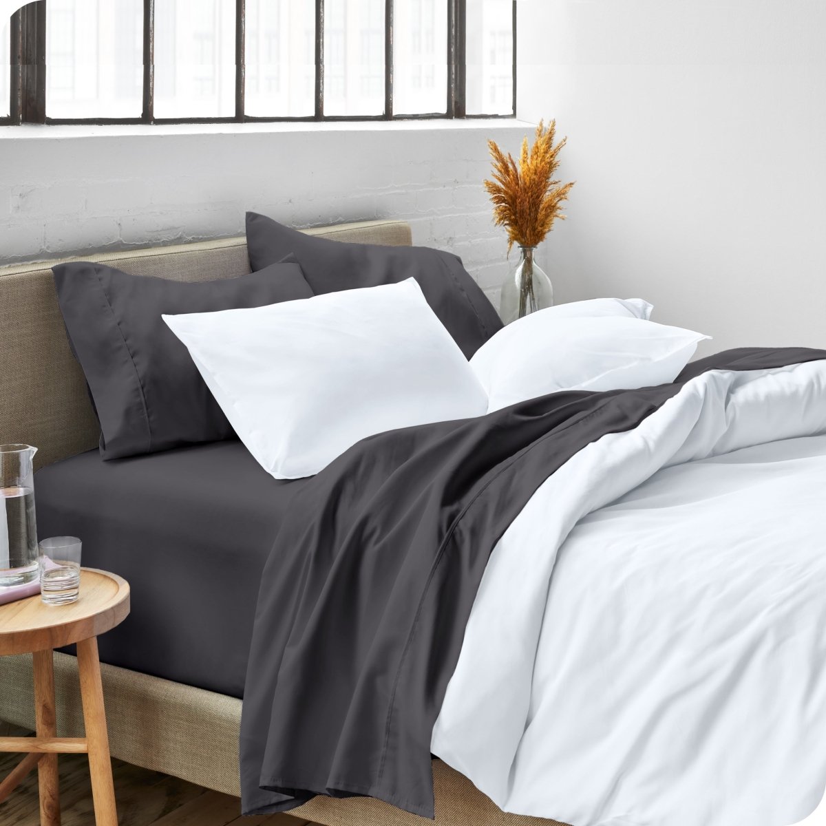 A side view of a bed made with microfiber sheets and a white duvet cover