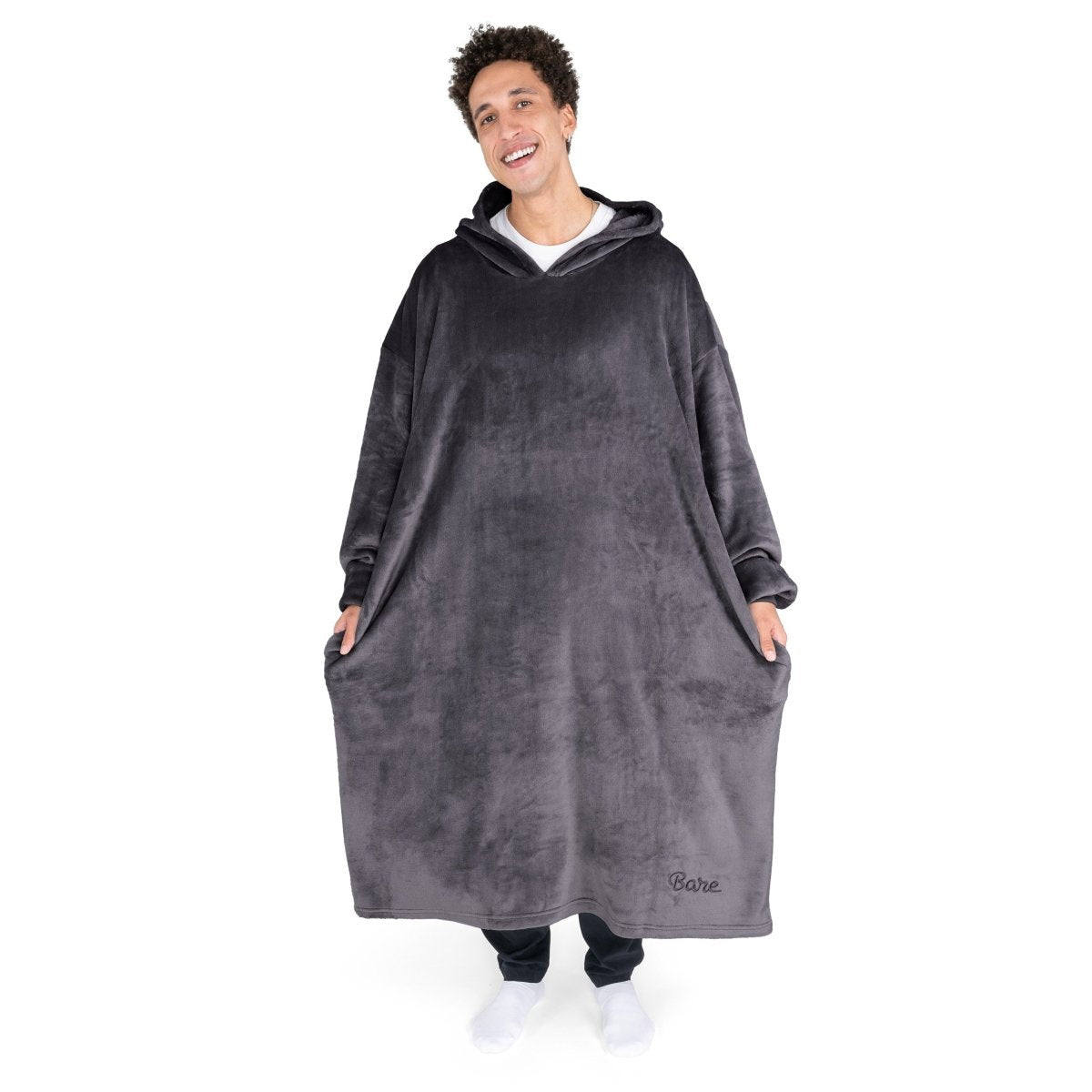 An adult with long microplush wearable blanket on