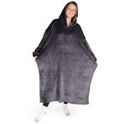 An adult is standing while wearing a long microplush wearable blanket