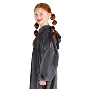 A girl has a microplush wearable blanket on