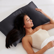 Woman lying on a bed with a pillow covered with a satin pillowcase