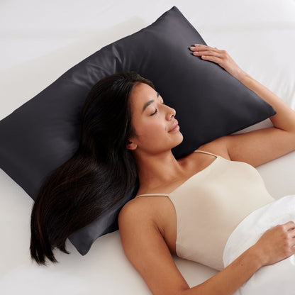 Woman lying on a bed with a pillow covered with a satin pillowcase