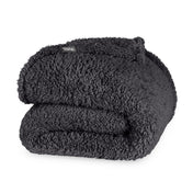 Folded textured blanket with a brand label on a white background