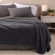 A double sided sherpa blanket on a bed