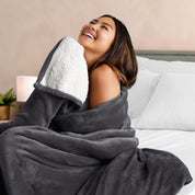 A woman smiling while wrapped in a sherpa blanket