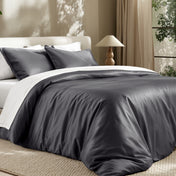 Bedding set on a bed in a bedroom with a lamp and window.
