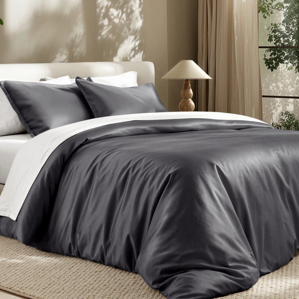 Bedding set on a bed in a bedroom with a lamp and window.
