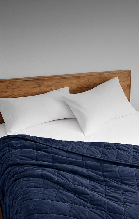 A weighted blanket draped over a bed