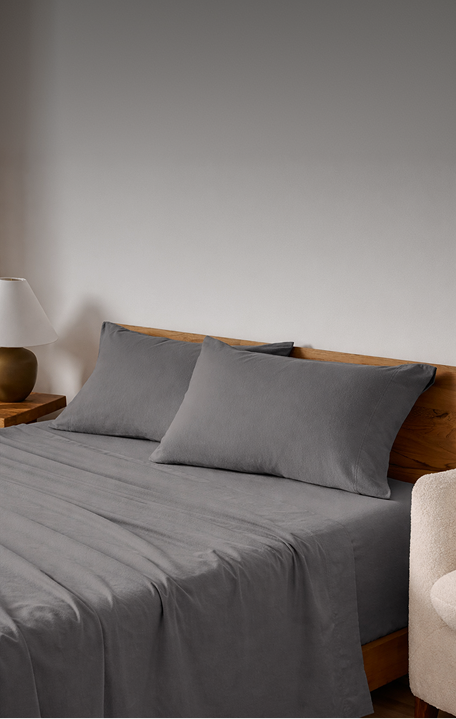 Grey sheets on a bed