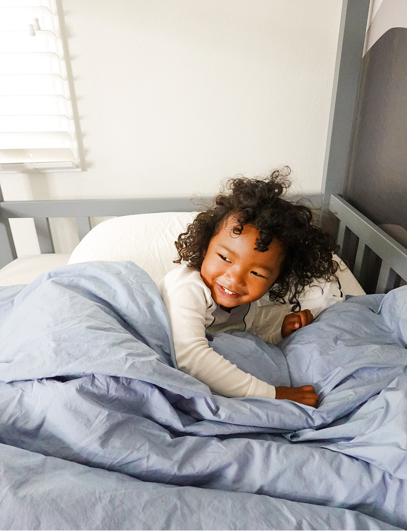Person lying asleep in bed with blue bedding review