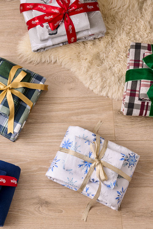 Flannel sheets in various patterns with ribbons on a wooden surface