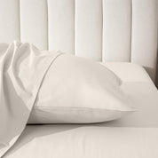 Pillow on a bed with a neutral headboard