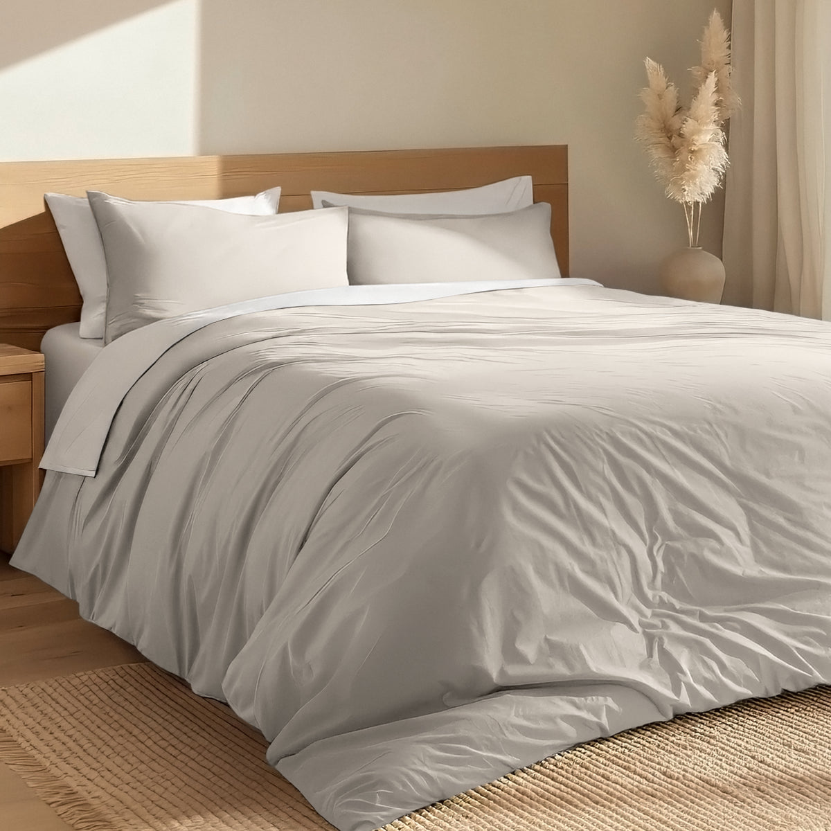 Bed with percale duvet cover set and wooden headboard in a room with a vase and decorative items.