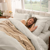 Woman sleeping on a bed made with percale sheets and duvet cover