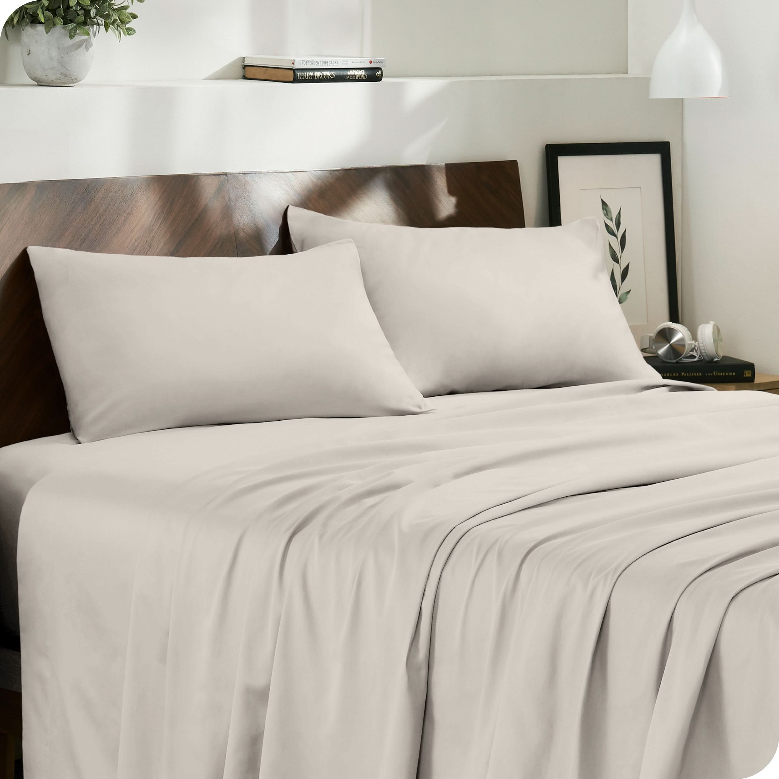 Diagonal view of modern bedroom with sateen sheets and pillowcases on the bed