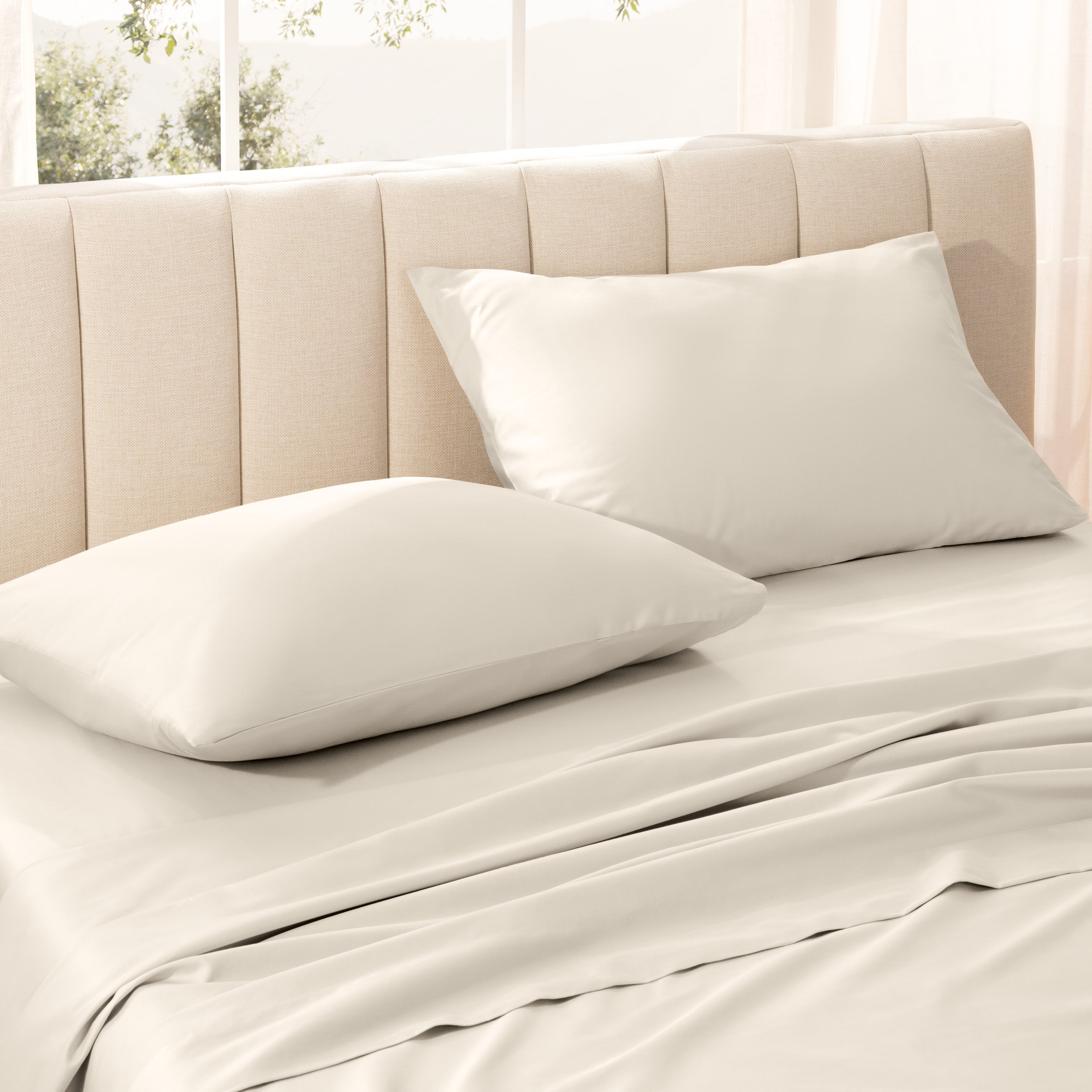 Sateen bedding set on a bed with a beige headboard.