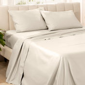 Bedding set on a bed with pillows in a bright room.