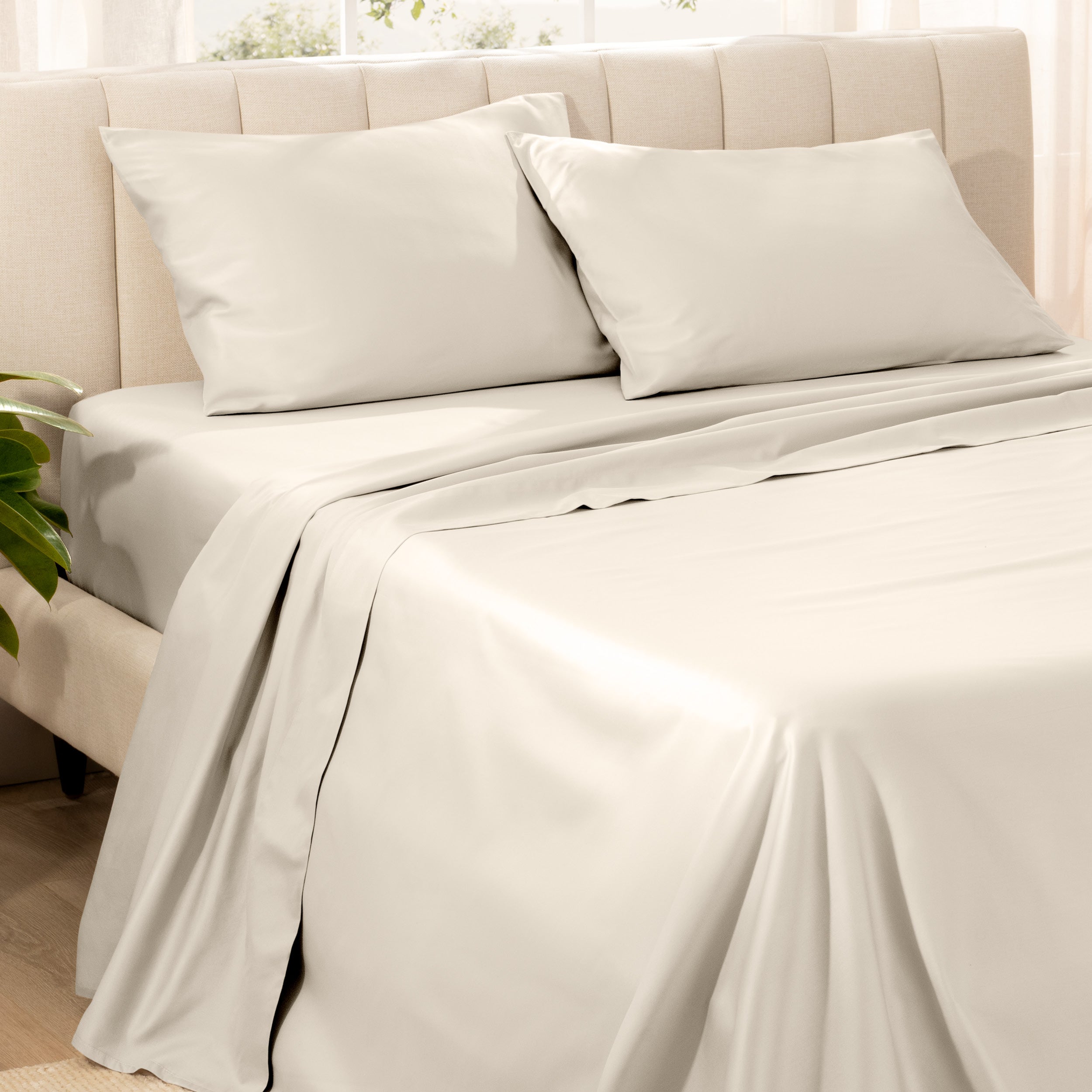 Bedding set on a bed with pillows in a bright room.