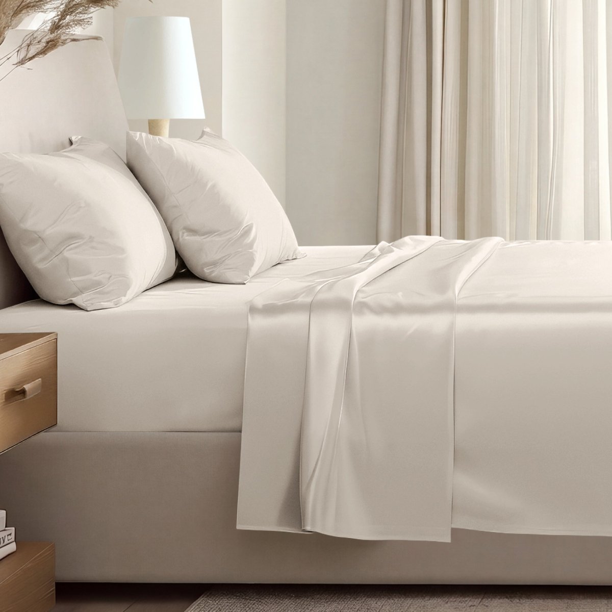 Sateen sheet set on a bed in a softly lit bedroom.