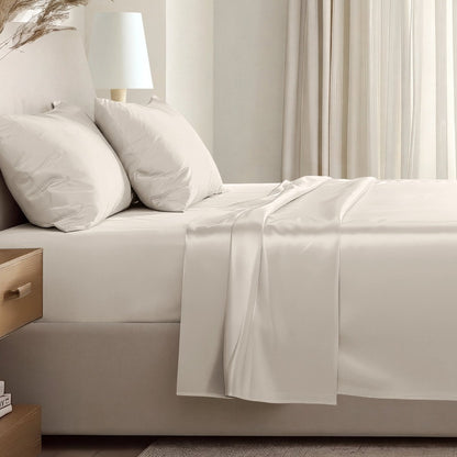 Sateen sheet set on a bed in a softly lit bedroom.