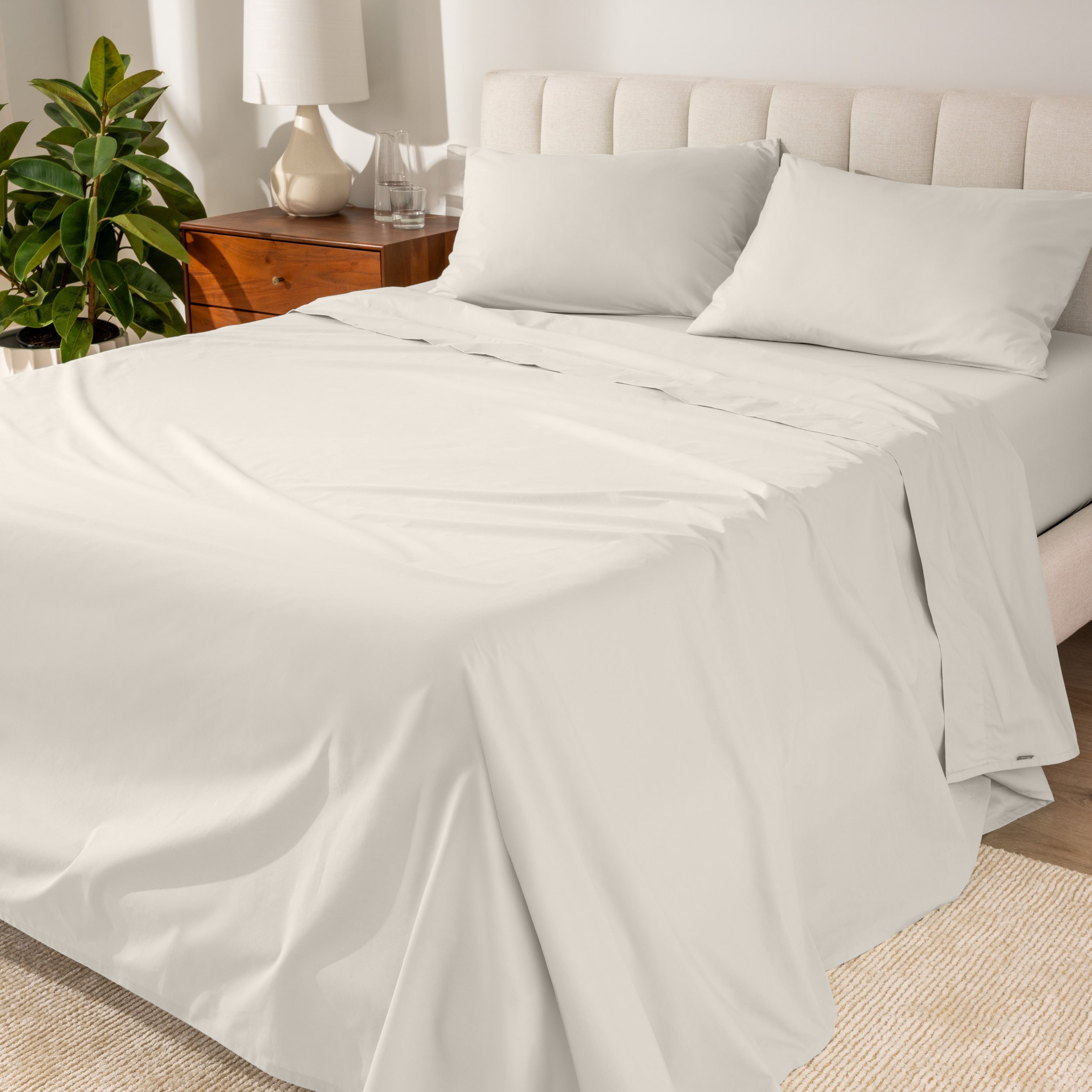 Percale sheets on a bed with a cream colored frame and headboard
