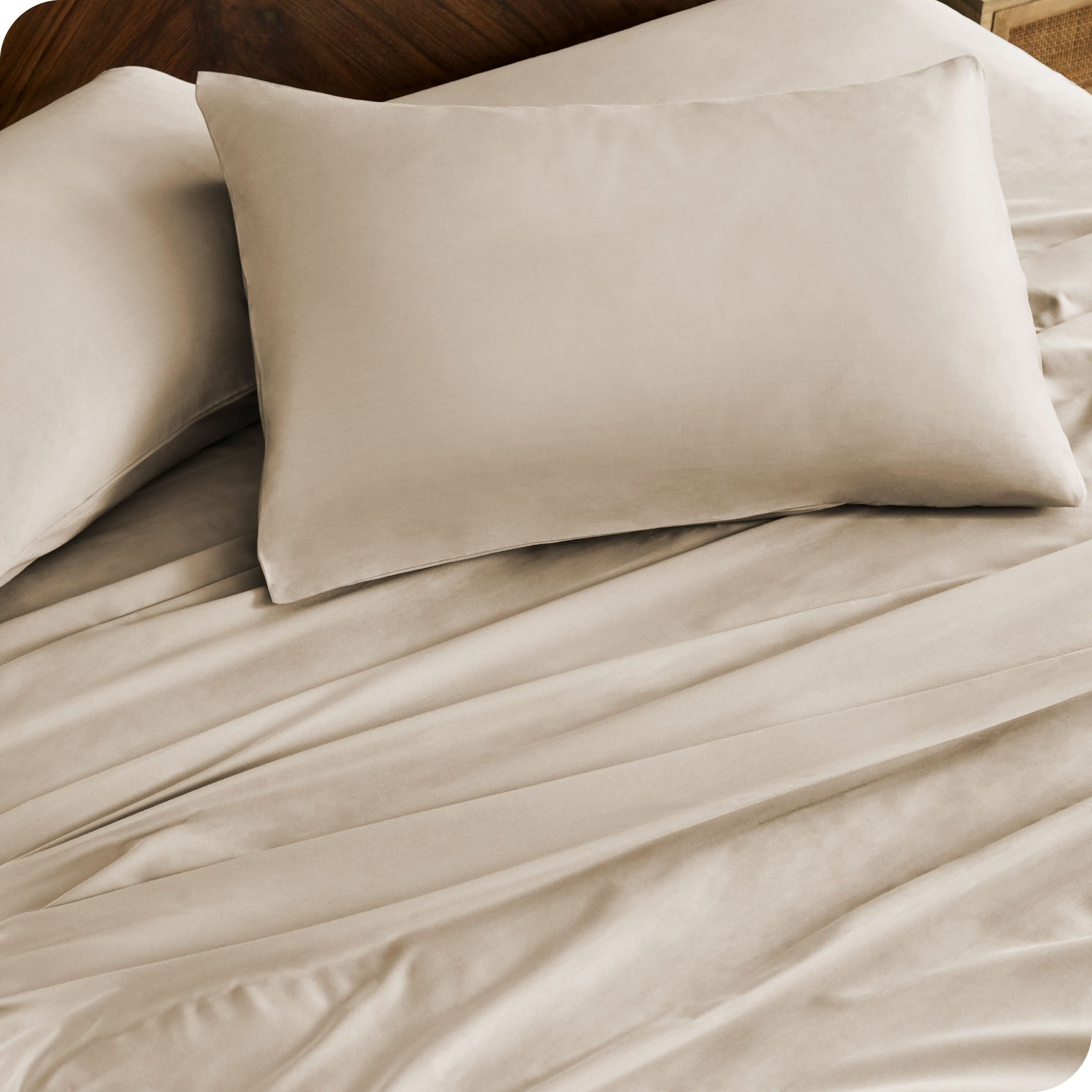 Close up of percale pillowcases and sheets on a bed