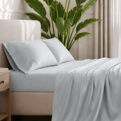 Ultra-soft sheets and pillowcases on a bed with a plant in the background