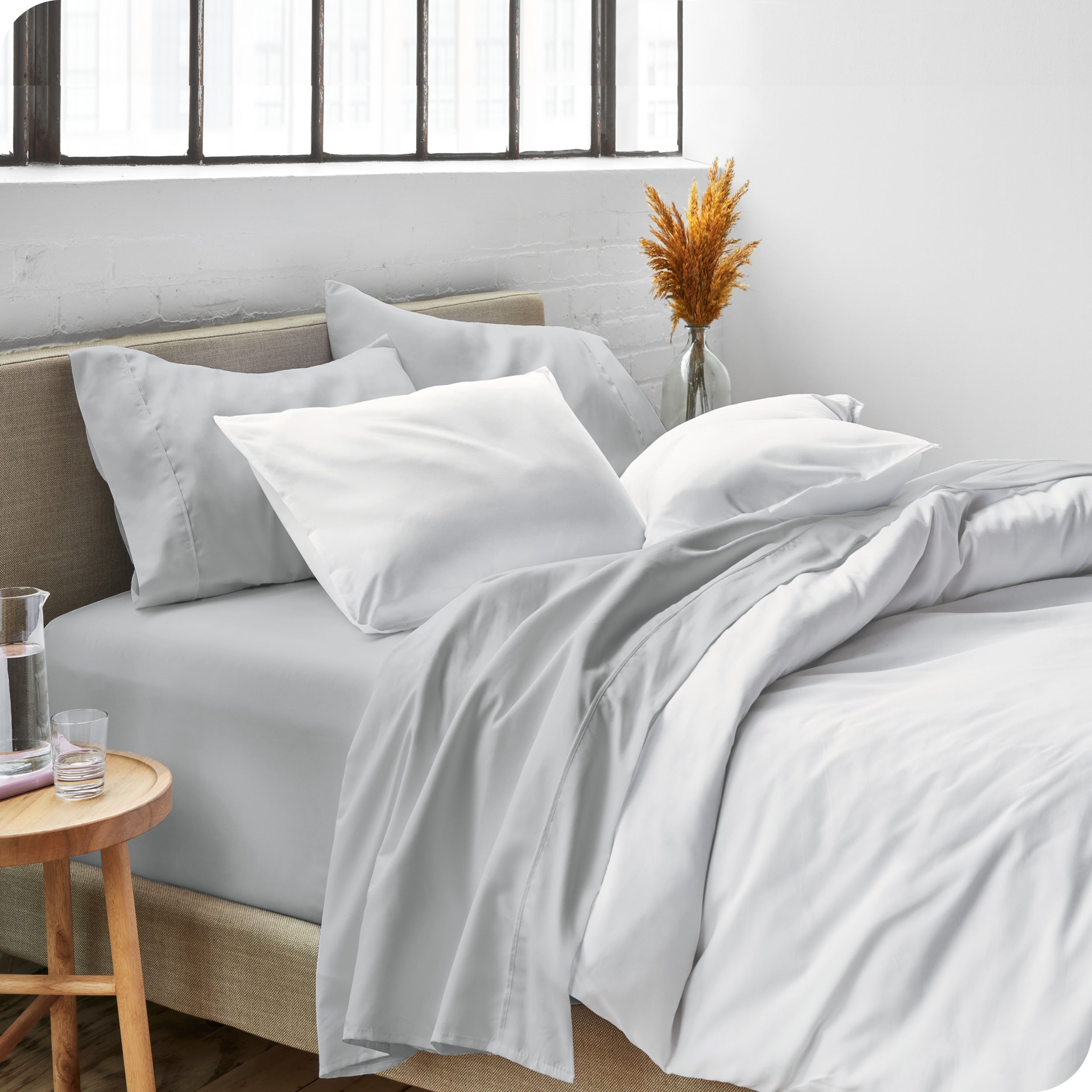 Sheets and a duvet cover on a bed in a bright bedroom